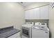 Well-equipped laundry room with modern washer and dryer and a granite countertop at 3263 Woodberry Ln # Lot 15, Sarasota, FL 34231