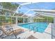 Inviting pool area with screened enclosure, poolside seating, and covered dining area at 3263 Woodberry Ln # Lot 15, Sarasota, FL 34231