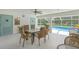 Covered poolside area with dining set and view of the sparkling blue pool at 3263 Woodberry Ln # Lot 15, Sarasota, FL 34231