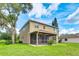 Two-story home featuring a covered, screened lanai and a well-maintained lawn with a large tree providing shade at 3303 Pine Top Dr, Valrico, FL 33594