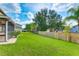 Spacious backyard with lush green lawn, a wooden fence, and mature trees offering privacy at 3303 Pine Top Dr, Valrico, FL 33594