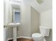 Powder room featuring a pedestal sink, mirror, toilet, and wood-look vinyl flooring at 3303 Pine Top Dr, Valrico, FL 33594