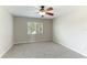 Bedroom with neutral paint and carpet, ceiling fan, and a window with tree views at 3303 Pine Top Dr, Valrico, FL 33594