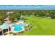 Aerial view of a community pool, playground, basketball court, and lush green spaces at 3303 Pine Top Dr, Valrico, FL 33594
