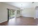 Open dining area featuring sliding glass doors, hardwood floors, a chandelier, and neutral paint at 3303 Pine Top Dr, Valrico, FL 33594