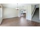 Open dining room with hardwood floors, chandelier, staircase, and an archway leading to the modern kitchen at 3303 Pine Top Dr, Valrico, FL 33594