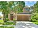 Charming two-story home featuring an attached garage and landscaped front yard with mature shade trees at 3303 Pine Top Dr, Valrico, FL 33594