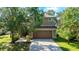 Attractive two-story home with an attached garage and well-maintained lawn, framed by mature trees at 3303 Pine Top Dr, Valrico, FL 33594