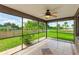 A screened-in patio shows views of the outdoors with tile flooring and a ceiling fan at 3303 Pine Top Dr, Valrico, FL 33594