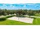 Community volleyball court and green spaces among mature trees and residential street at 3303 Pine Top Dr, Valrico, FL 33594