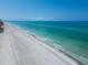 Expansive aerial view of a pristine beach with turquoise water and white sand under a clear blue sky at 3540 Gulf Of Mexico Dr # 303, Longboat Key, FL 34228