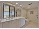 Well-lit bathroom with double sink vanity, bidet and large window with blinds at 3540 Gulf Of Mexico Dr # 303, Longboat Key, FL 34228