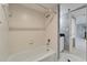 Bathroom featuring a tub-shower with white tile surround, shower head, and a white tile floor at 3540 Gulf Of Mexico Dr # 303, Longboat Key, FL 34228