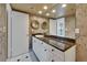 Elegant bathroom featuring double sinks, a vanity with granite counters, and stylish floral wallpaper at 3540 Gulf Of Mexico Dr # 303, Longboat Key, FL 34228
