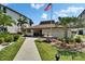 A charming clubhouse with an American flag, water fountain, and beautiful landscaping at 3540 Gulf Of Mexico Dr # 303, Longboat Key, FL 34228