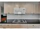 Close-up on a kitchen cooktop with a modern microwave and granite countertops at 3540 Gulf Of Mexico Dr # 303, Longboat Key, FL 34228