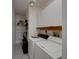 Functional laundry room with washer, dryer, white cabinets, and convenient shelving for organized storage solutions at 3540 Gulf Of Mexico Dr # 303, Longboat Key, FL 34228