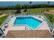 Aerial view of a community pool with ample seating surrounded by tropical landscaping at 3540 Gulf Of Mexico Dr # 303, Longboat Key, FL 34228