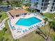 Aerial view of a community pool and clubhouse with ample seating surrounded by lush landscaping at 3540 Gulf Of Mexico Dr # 303, Longboat Key, FL 34228