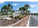 Community sign for Buttonwood Cove with lush landscaping at entrance at 3540 Gulf Of Mexico Dr # 303, Longboat Key, FL 34228