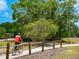 Picturesque bike trail featuring a cyclist, wooden fence, and lush landscaping for a pleasant outdoor adventure at 3627 Longmeadow # 39, Sarasota, FL 34235