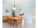 Light and bright dining room features a pendant light, soft blue walls, and light tile floors at 3627 Longmeadow # 39, Sarasota, FL 34235