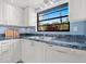 The kitchen features white cabinets, modern appliances, solid surface counters, and a large garden window at 3627 Longmeadow # 39, Sarasota, FL 34235