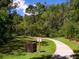 Scenic nature trail with lush greenery, a trash receptacle, and clear signage for a tranquil outdoor experience at 3627 Longmeadow # 39, Sarasota, FL 34235