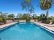 Community pool with lounge chairs, mature landscaping, and inviting clear blue water at 3627 Longmeadow # 39, Sarasota, FL 34235