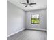 This bedroom has a window, gray walls, gray wood-look floors, and recessed lighting at 3637 Petunia Ter, North Port, FL 34286