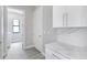 Hallway featuring white cabinets and a peek into the laundry room with a washer at 3637 Petunia Ter, North Port, FL 34286