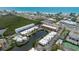 Aerial view of coastal condos near the beach and shops, showcasing waterfront access and community amenities at 3803 E Bay Dr # 10, Bradenton Beach, FL 34217