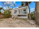 Charming home featuring backyard with stairs leading to a deck and lush palm trees at 3803 E Bay Dr # 10, Bradenton Beach, FL 34217