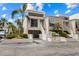 Modern condo featuring covered parking, a stairway to the front door, and lush tropical landscaping at 3803 E Bay Dr # 10, Bradenton Beach, FL 34217