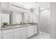 Elegant bathroom featuring double vanities, granite countertops, and a tiled walk-in shower at 416 Delaney St, Port Charlotte, FL 33954