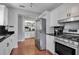 Bright kitchen featuring white cabinets, black granite countertops, stainless steel appliances, and hardwood floors at 417 20Th W Ave, Palmetto, FL 34221