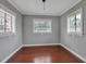 Bright, empty room featuring three windows, wood floors and gray walls at 417 20Th W Ave, Palmetto, FL 34221