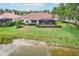 Backyard with a screened-in lanai, manicured lawn, and waterfront views at 431 Fieldstone Dr, Venice, FL 34292