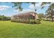 Spacious backyard with lush green grass and a screened-in lanai, perfect for outdoor living at 431 Fieldstone Dr, Venice, FL 34292