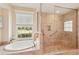 Bright bathroom offering a garden tub with a view of the neighborhood, and seamless glass enclosed shower at 431 Fieldstone Dr, Venice, FL 34292