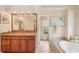 Bathroom with granite vanity, art, a soaking tub with a window view, and seamless glass shower at 431 Fieldstone Dr, Venice, FL 34292