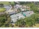 An aerial view shows the community clubhouse with pools and tennis courts surrounded by lush trees at 431 Fieldstone Dr, Venice, FL 34292