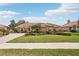 Lovely single-story home with a terracotta roof, mature landscaping, and a circular driveway at 431 Fieldstone Dr, Venice, FL 34292