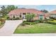 Beautiful single-story home with a terracotta roof, manicured landscaping, and a circular driveway at 431 Fieldstone Dr, Venice, FL 34292