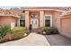 Home's entrance with double doors, transom window, and landscaped pathway leading to the front entrance at 431 Fieldstone Dr, Venice, FL 34292