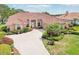 Beautifully landscaped home with a red tile roof, inviting double door entry, and a brick driveway at 431 Fieldstone Dr, Venice, FL 34292