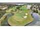 Aerial view of a well-maintained golf course with sand traps and blue lakes at 431 Fieldstone Dr, Venice, FL 34292