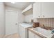 Functional laundry room with washer, dryer, sink, and ample cabinet storage space at 431 Fieldstone Dr, Venice, FL 34292