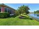 Beautiful backyard with lush lawn, mature trees, and serene water views at 4322 Reflections Pkwy, Sarasota, FL 34233