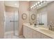 Bright bathroom featuring dual sinks, white cabinetry, and a glass-enclosed shower at 4322 Reflections Pkwy, Sarasota, FL 34233